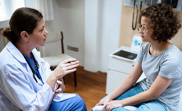 Teenager in exam room speaking to a doctor